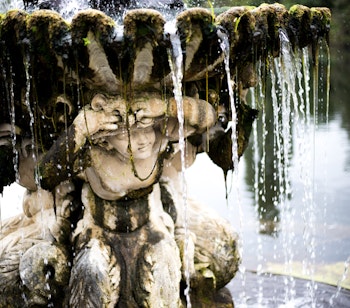 Historisk fontæne i den italienske have i Kensington, London med klassisk arkitektur omgivet af grønne områder og rolige vandpartier