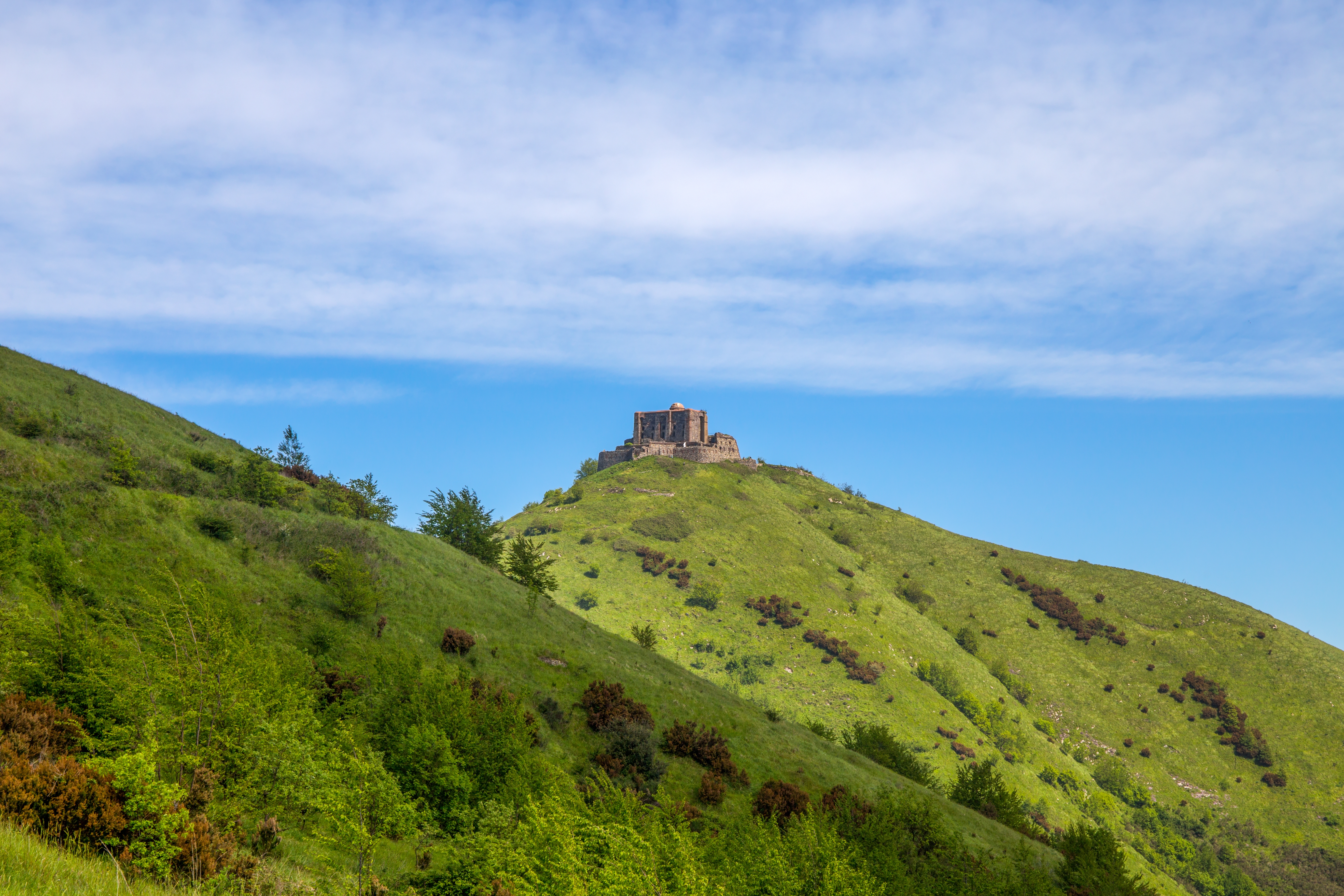 Historisk fæstning Forte Diamante på bakkekam i Genova med frodig grøn natur og blå himmel