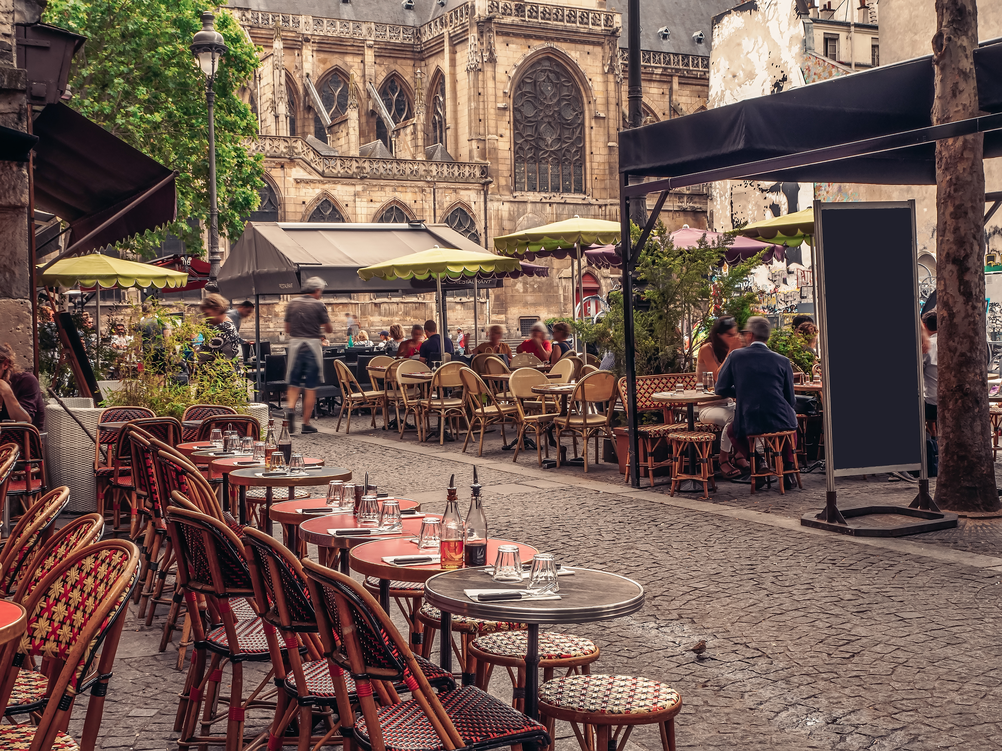Traditionel fransk sidewalk cafe med udendørs spisning i historisk europæisk bymidte