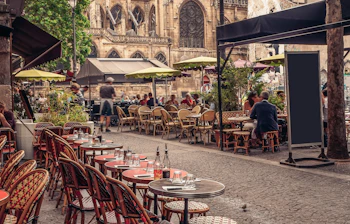 Traditionel fransk sidewalk cafe med udendørs spisning i historisk europæisk bymidte