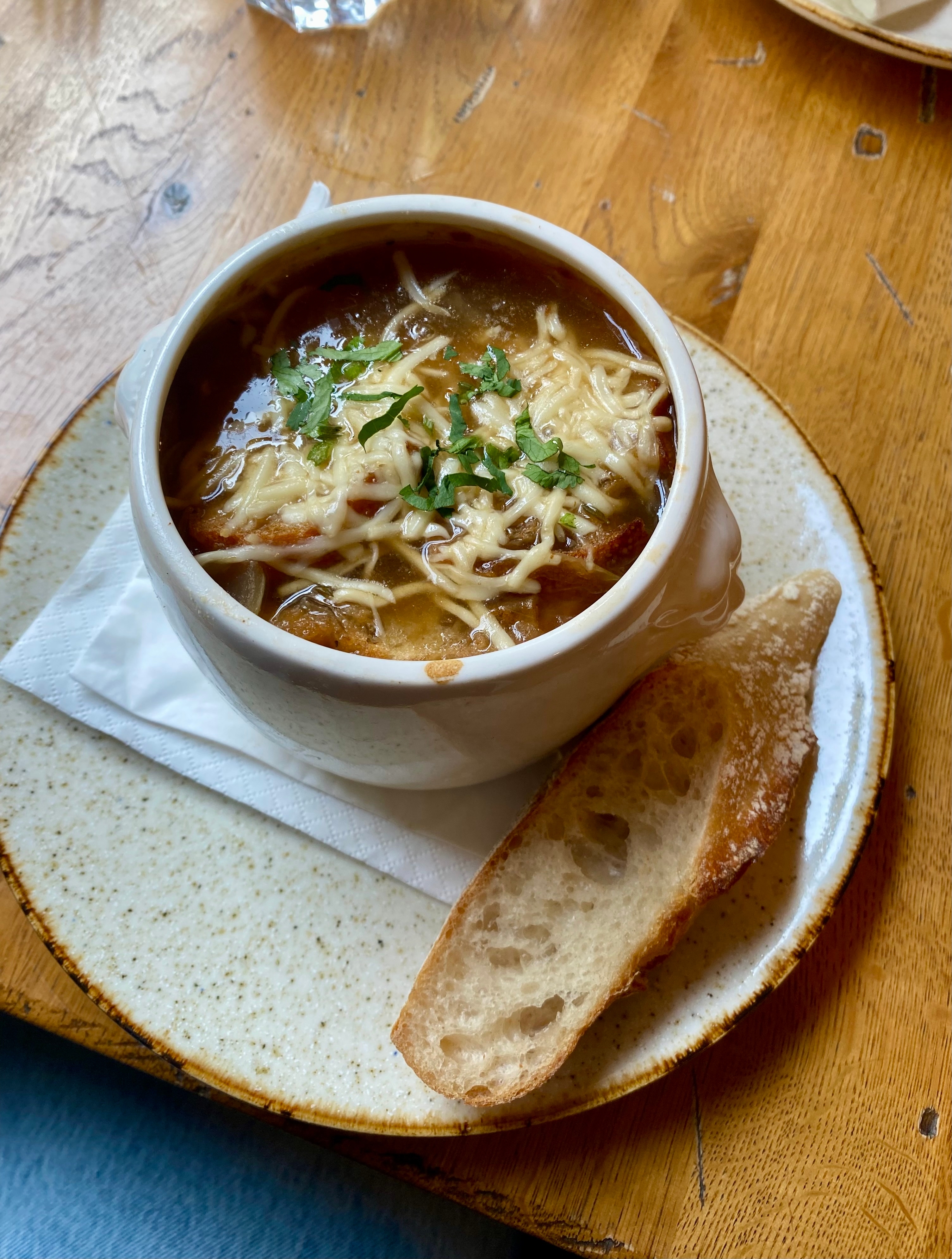 Traditionel fransk løgsuppe med smeltet ost og brød, serveret på en autentisk parisisk bistro