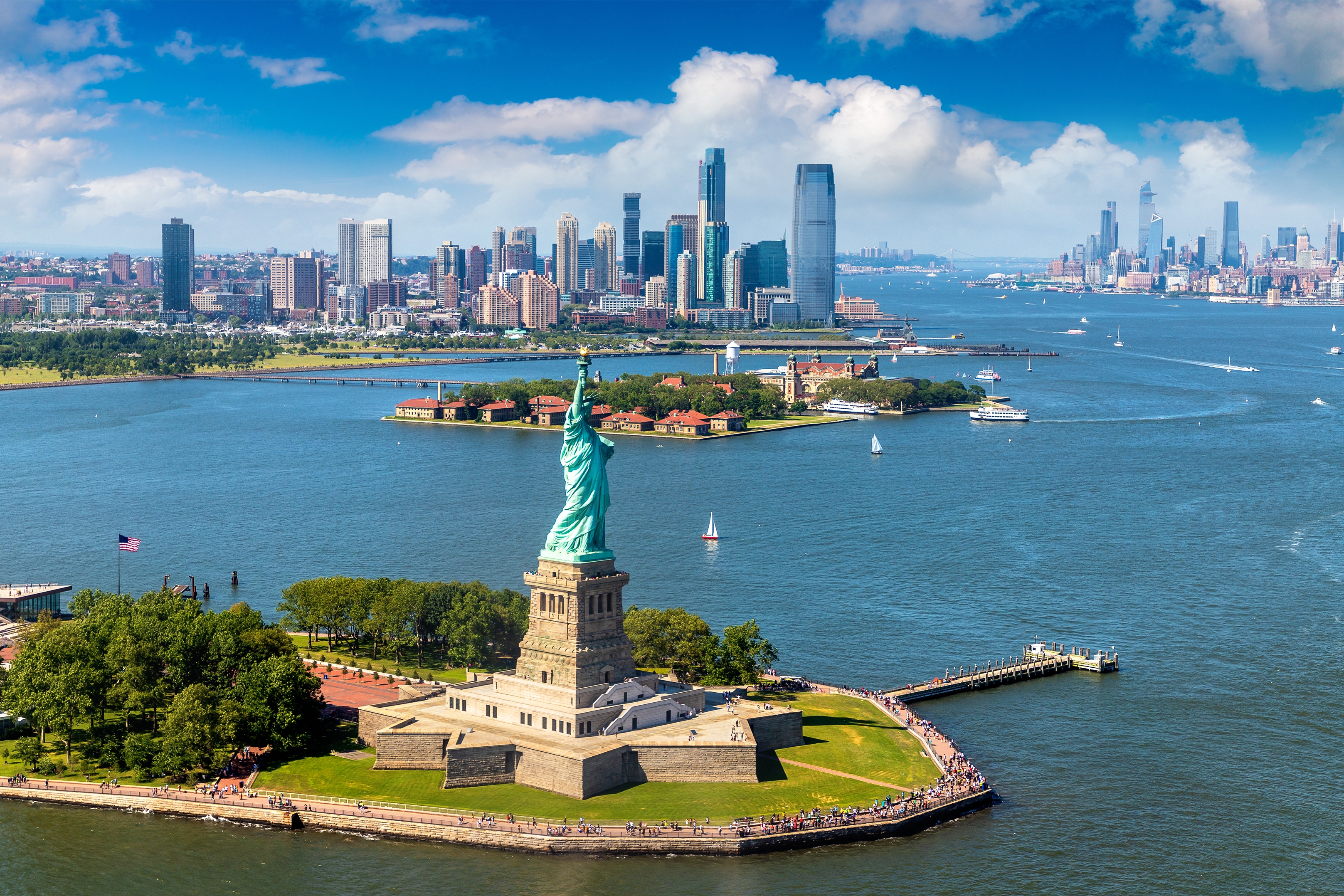Luftfoto af Frihedsgudinden på Liberty Island med Manhattans skyline og havn i New York City