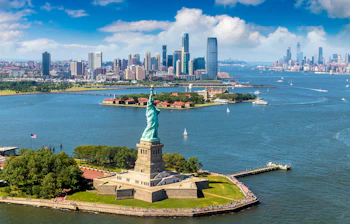 Luftfoto af Frihedsgudinden på Liberty Island med Manhattans skyline og havn i New York City