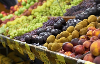 Farverige friske druer, kiwi og figner til salg på et lokalt frugtmarked ved Middelhavet, perfekt til at opleve den autentiske madkultur på din rejse