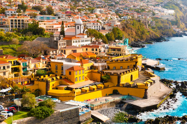 Panoramaudsigt over Funchals historiske centrum med Fuerte De Madeira-fæstningen, farverige bygninger og havnen omgivet af Atlanterhavet på den portugisiske ø Madeira
