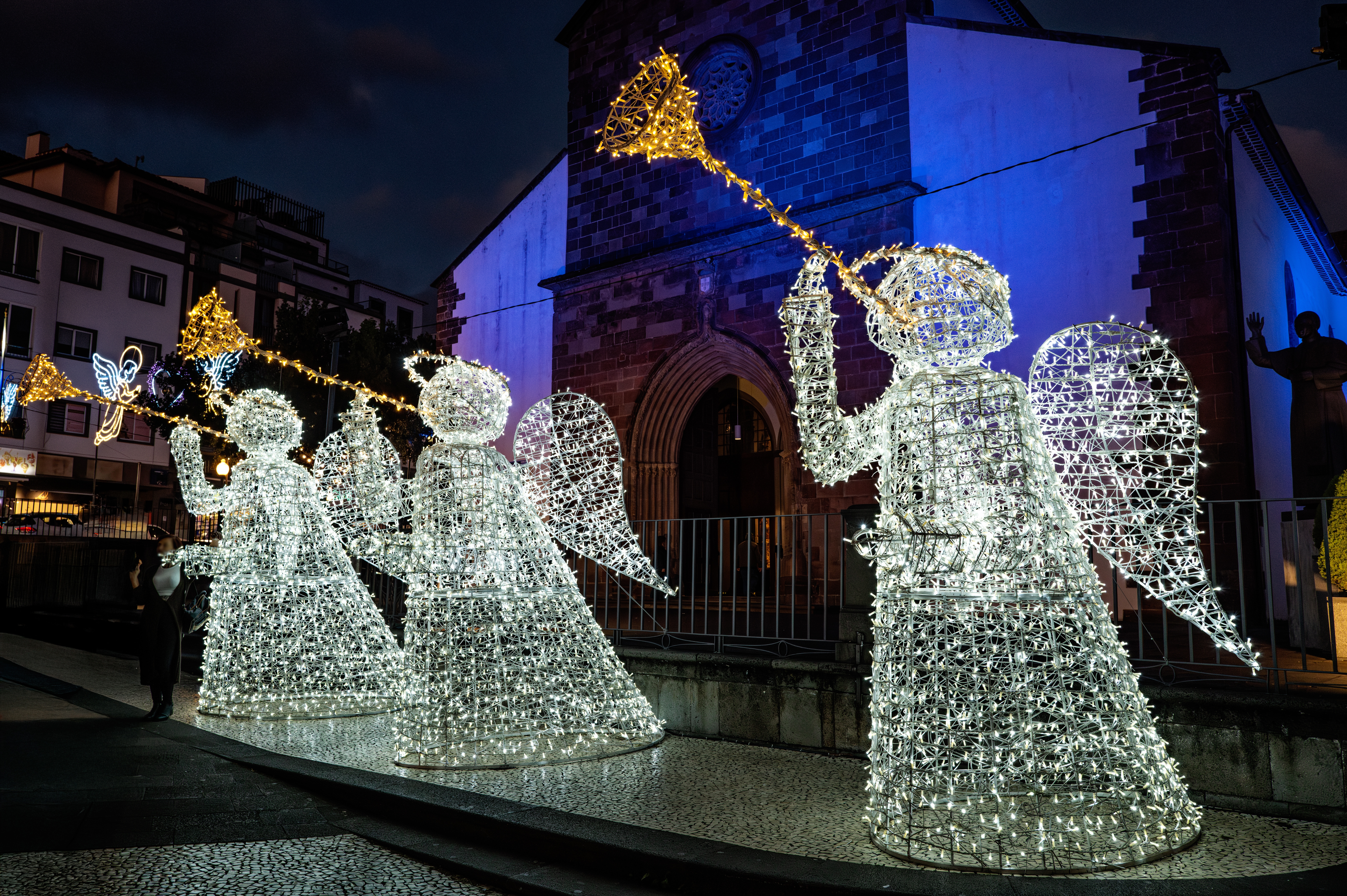 Lysende engledekoration til jul foran historisk stenkirke i Funchal på Madeira om aftenen