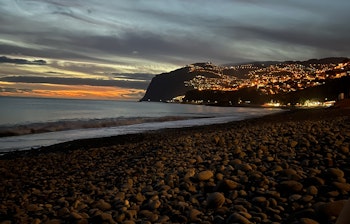 Hyggelige gader i Funchals gamle bydel "Zona Velha" på Madeira, hvor lokale og turister nyder den fredelige atmosfære omgivet af imponerende bjerglandskab