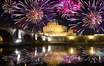 Farvestrålende fyrværkeri over Castel Sant'Angelo og Tiberen i Rom under nattefestligheder i Italiens historiske hovedstad