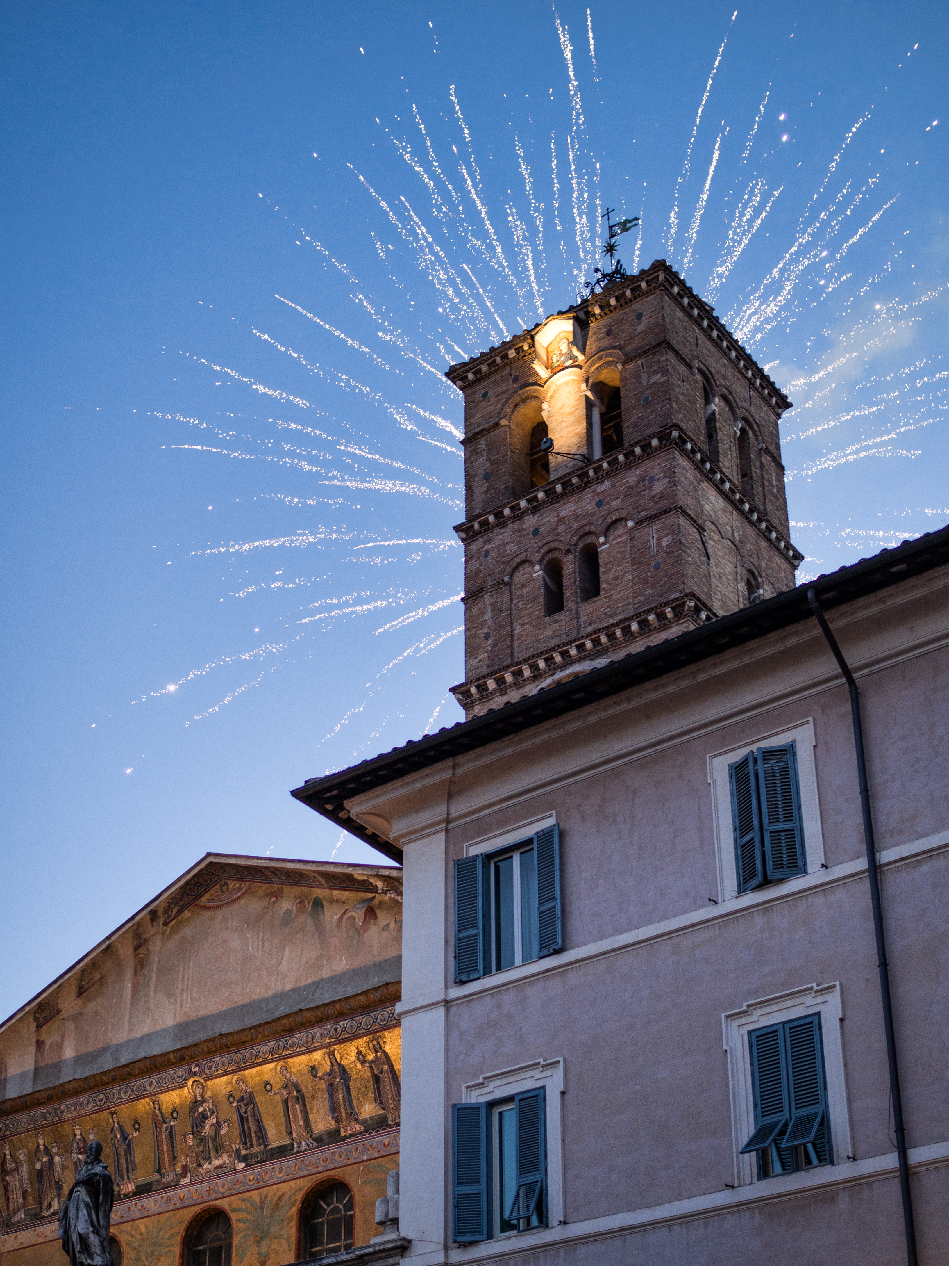 Spektakulære fyrværkeri bag det middelalderlige klokketårn ved Santa Maria in Trastevere basilika i Rom, Italien