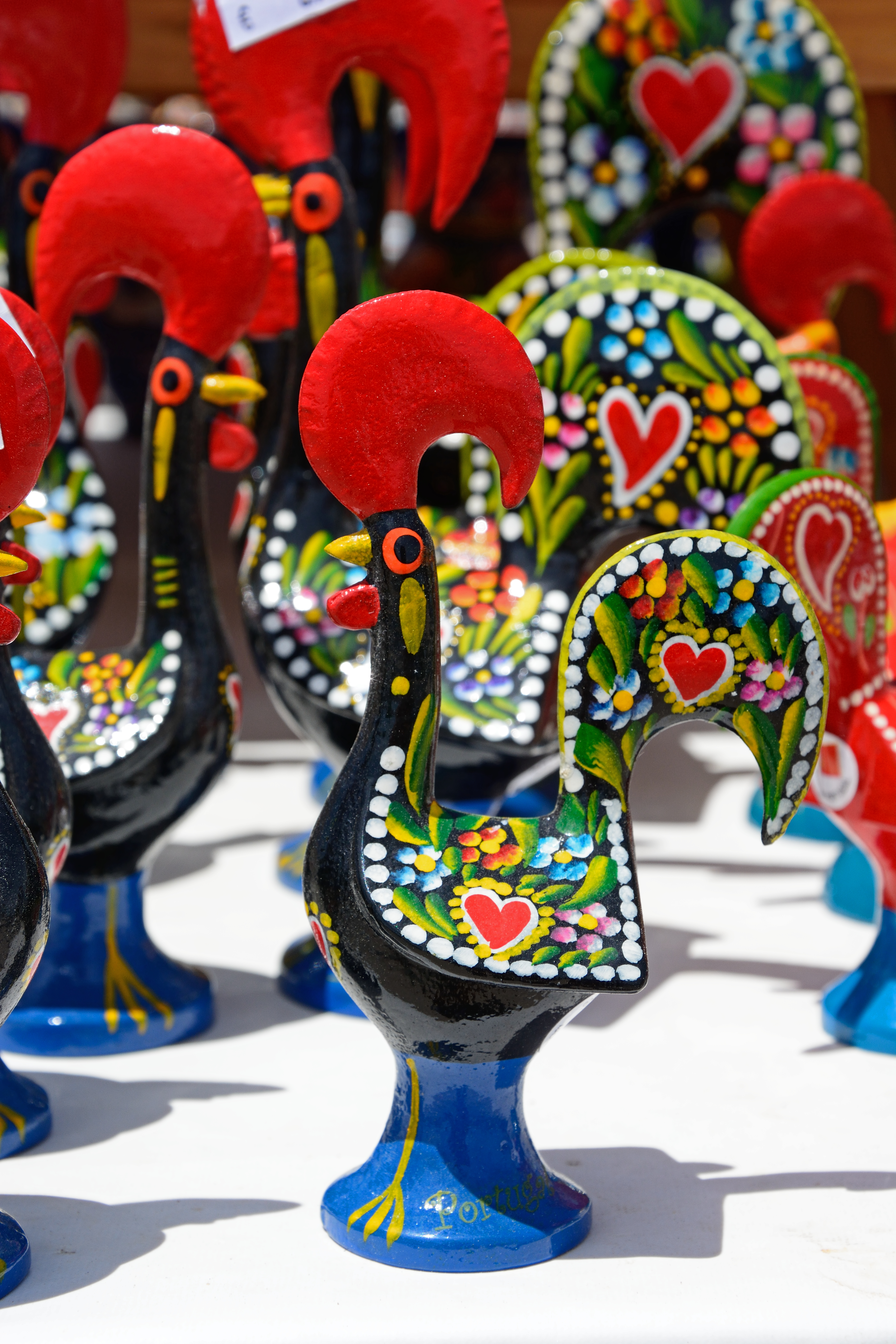Farverige keramiske Barcelos-haner, Portugals uofficielle nationalsymbol, håndmalet i traditionelle mønstre og udstillet som souvenirs i Algarve