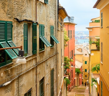 Malerisk udsigt over den gamle skrånende gade der fører ned til havnen i Genova, Ligurien, Italien