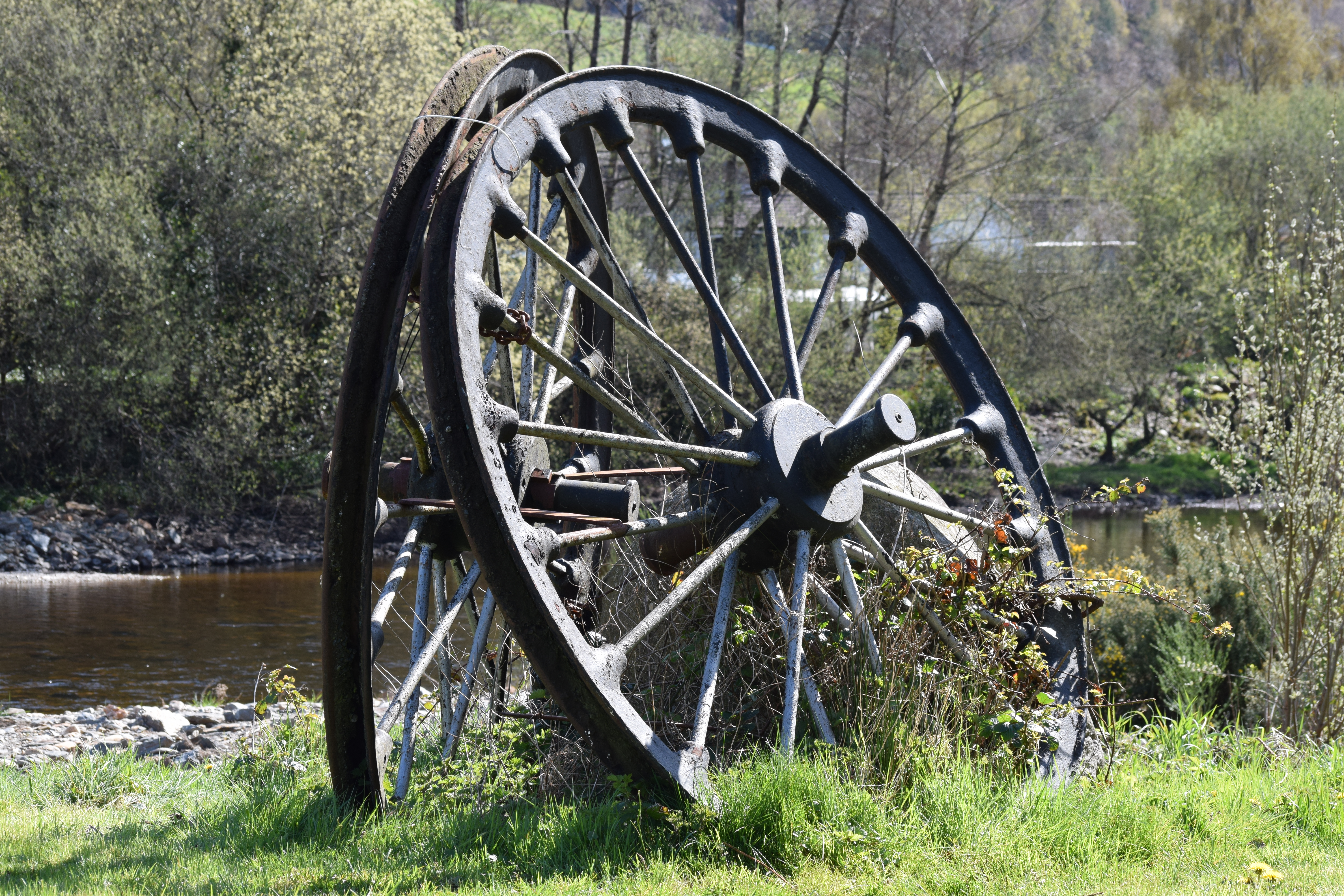 Gammelt jernvognhjul opstillet ved floden i Avoca, County Wicklow, Irland