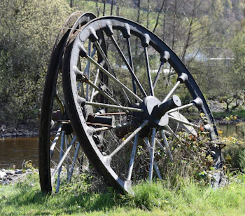 Gammelt jernvognhjul opstillet ved floden i Avoca, County Wicklow, Irland