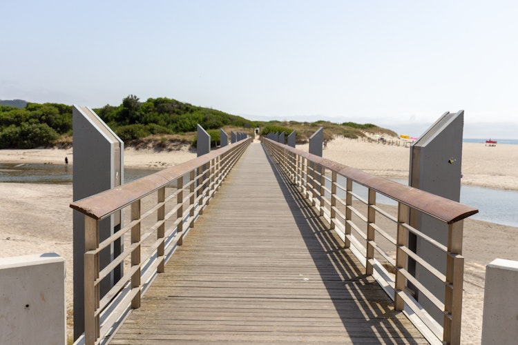 Charmerende træbro over Ancora-floden ved Vila Praia de Ancora på Portugals nordkyst med sandstrand og blå himmel