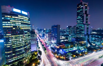 Oplyste skyskrabere og moderne bylandskab i Gangnam-distriktet om natten med trafiklysspor i Seoul, Sydkorea