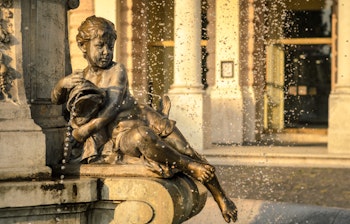 Den historiske Ganymede Fontæne i Bratislava med bronzeskulptur af den mytologiske figur, beliggende foran det Slovakiske Nationalteater i gyldent aftenlys
