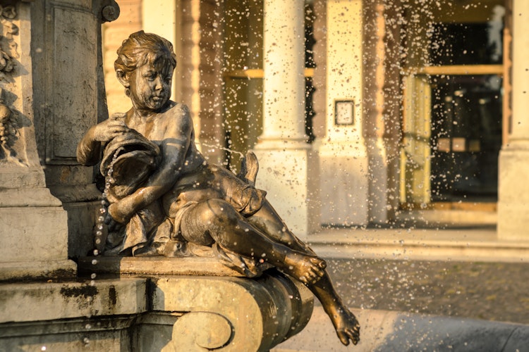 Den historiske Ganymede Fontæne i Bratislava med bronzeskulptur af den mytologiske figur, beliggende foran det Slovakiske Nationalteater i gyldent aftenlys