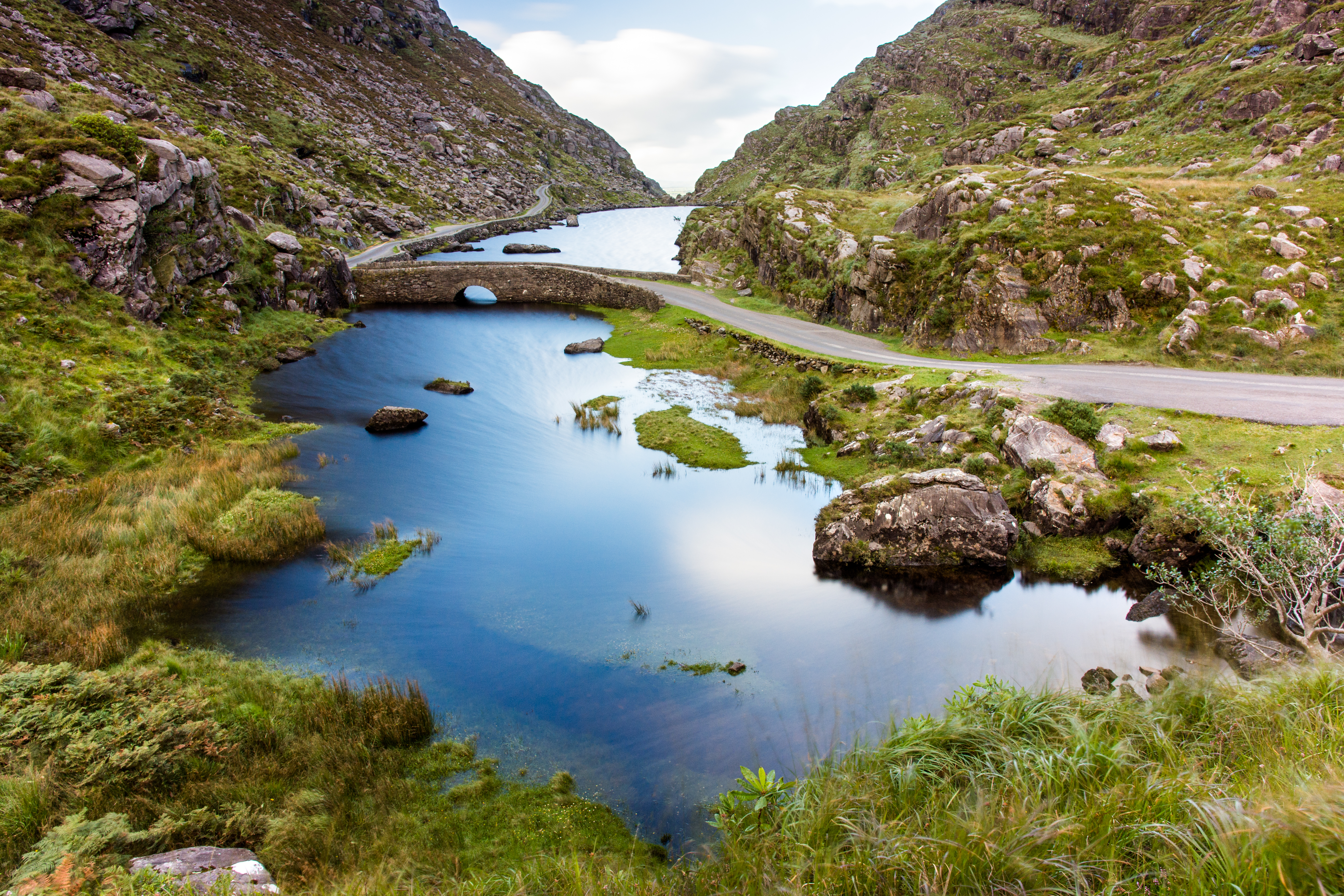 Det maleriske Gap of Dunloe bjergpas med den blå flod Loe, der snor sig gennem den grønne dal i County Kerry, Irland
