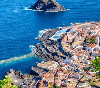 Luftudsigt over den charmerende kystby Garachico på Tenerife med dramatiske klipper og naturlige havnebassiner ved Atlanterhavet