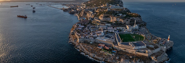 Luftfoto af Gibraltar strand ved solnedgang, der viser det ikoniske britiske landskab og kystlinje.