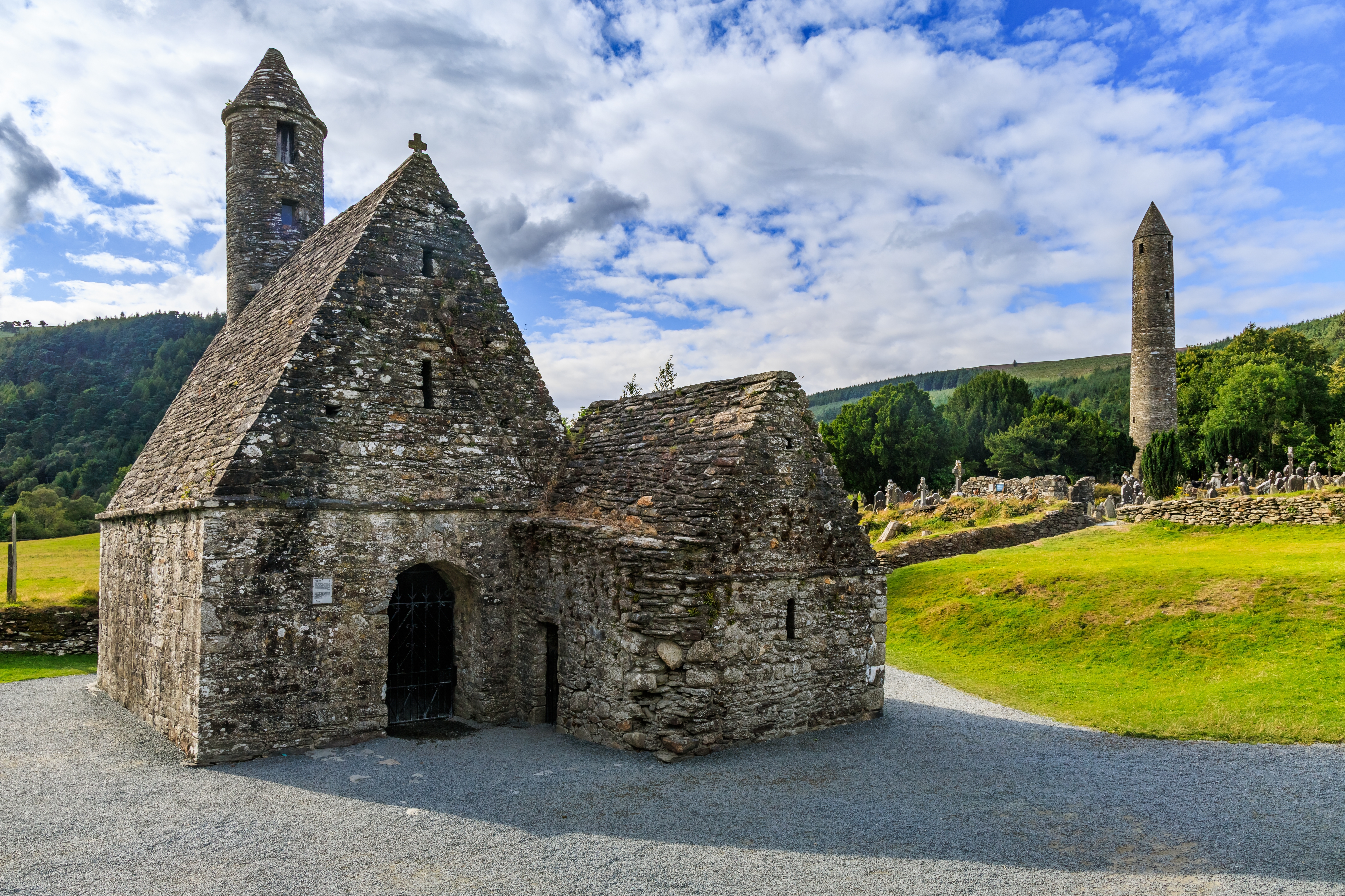 Saint Kevins Kirke og det runde tårn ved det middelalderlige klostersamfund Glendalough i County Wicklow, Irland