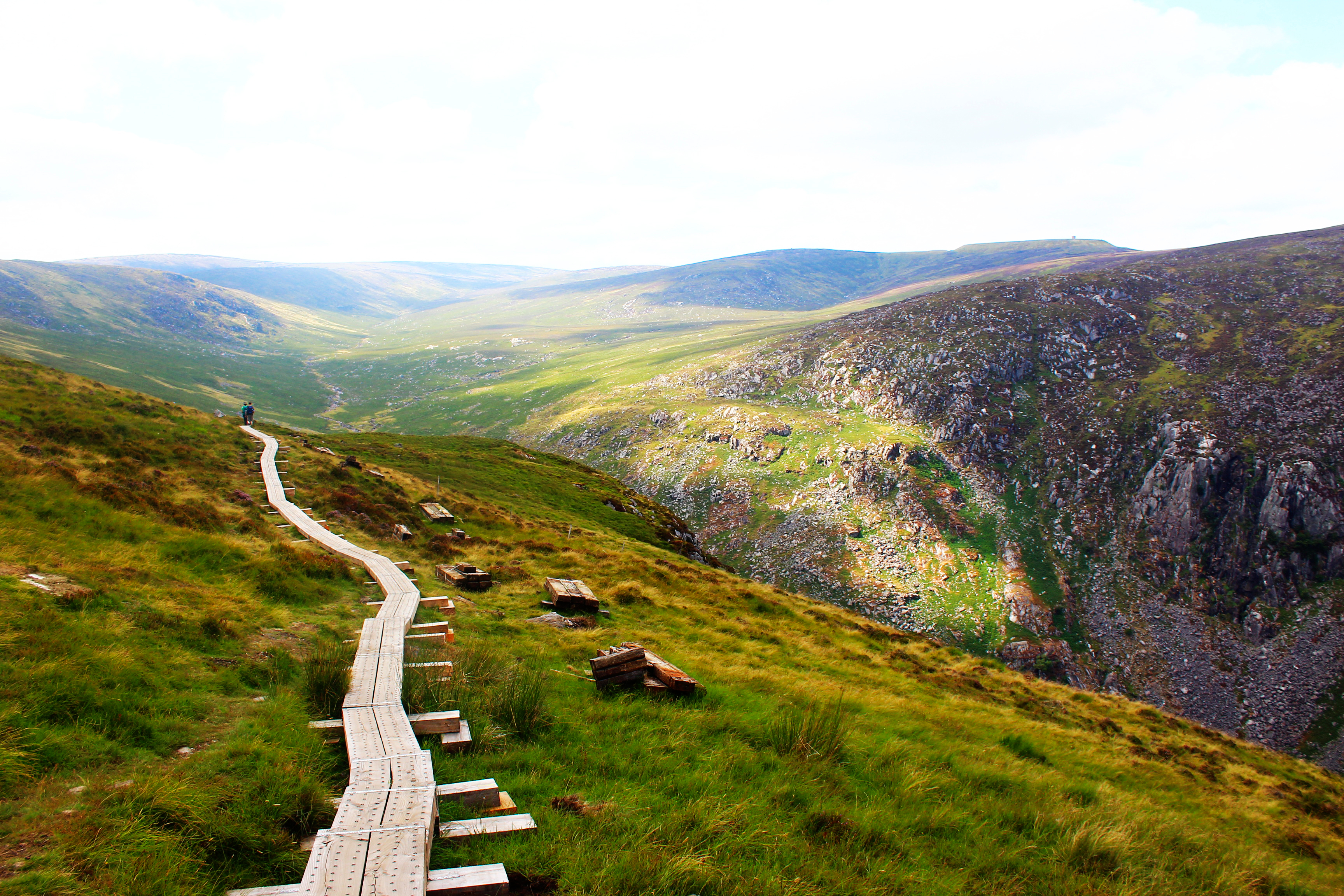 Træstikvandrerute langs klipperne over Glendalough-dalen i County Wicklow, Irland, på en solrig sommerdag