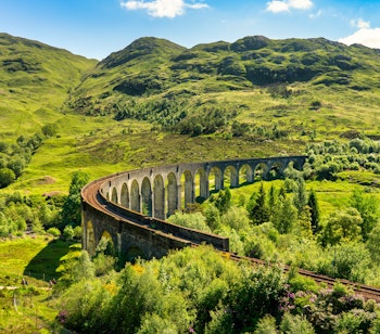 Den berømte Glenfinnan Viadukt i det skotske højland, kendt fra Harry Potter-filmene, omgivet af betagende bjerglandskab
