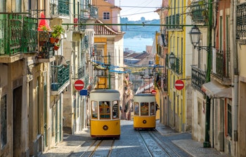 Den gule Gloria-sporvogn kører op ad den stejle bakke i Lissabons historiske centrum, et ikonisk transportmiddel i Portugals hovedstad
