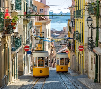 Den gule Gloria-sporvogn kører op ad den stejle bakke i Lissabons historiske centrum, et ikonisk transportmiddel i Portugals hovedstad