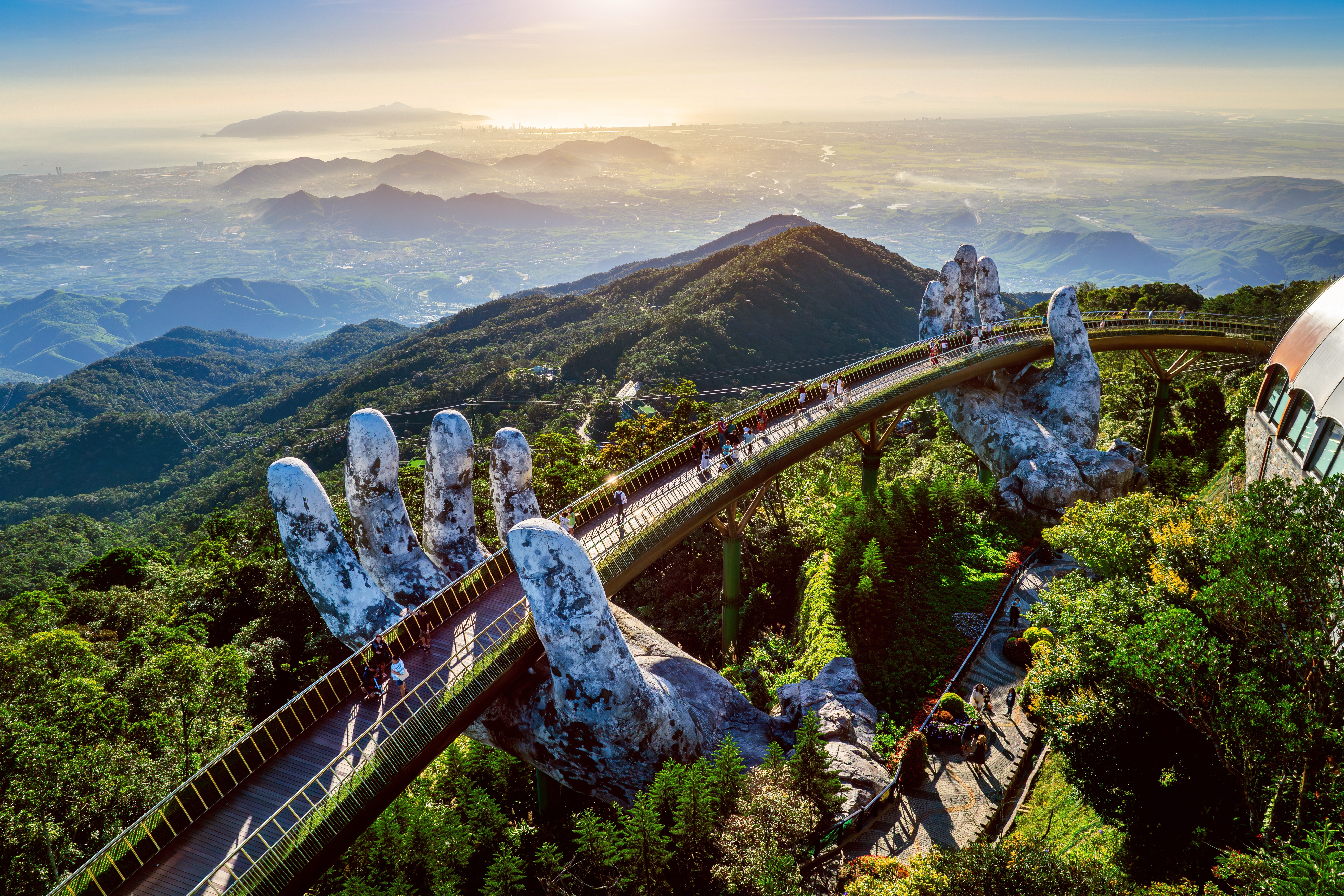 Turister går over den berømte Golden Bridge båret af kæmpe stenhænder i Ba Na Hills nær Da Nang, Vietnam