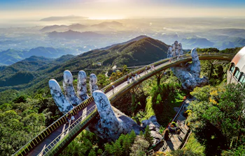 Turister går over den berømte Golden Bridge båret af kæmpe stenhænder i Ba Na Hills nær Da Nang, Vietnam