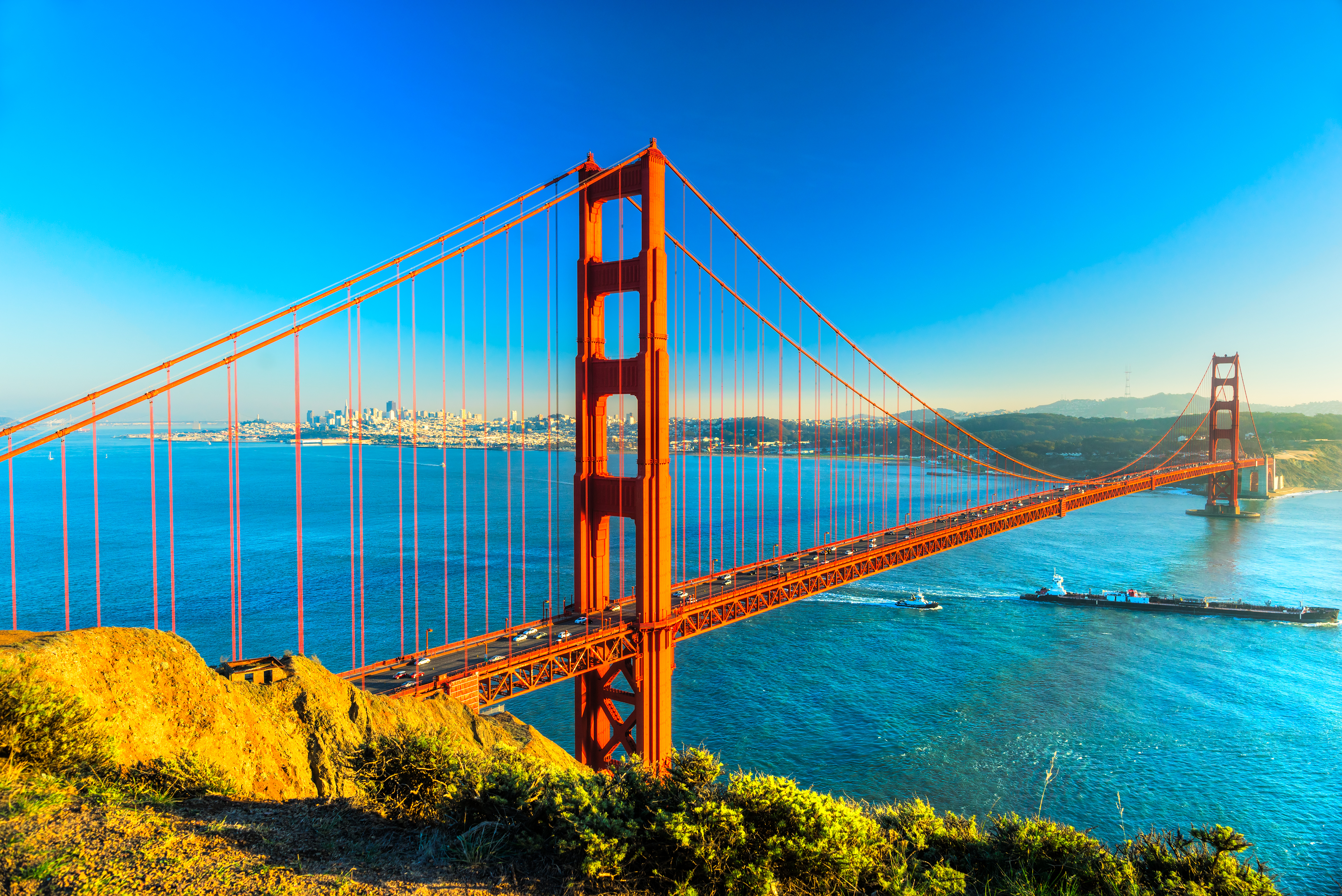 Golden Gate Bridge i San Francisco med blåt vand og byens skyline