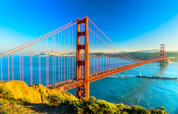 Golden Gate Bridge i San Francisco med blåt vand og byens skyline