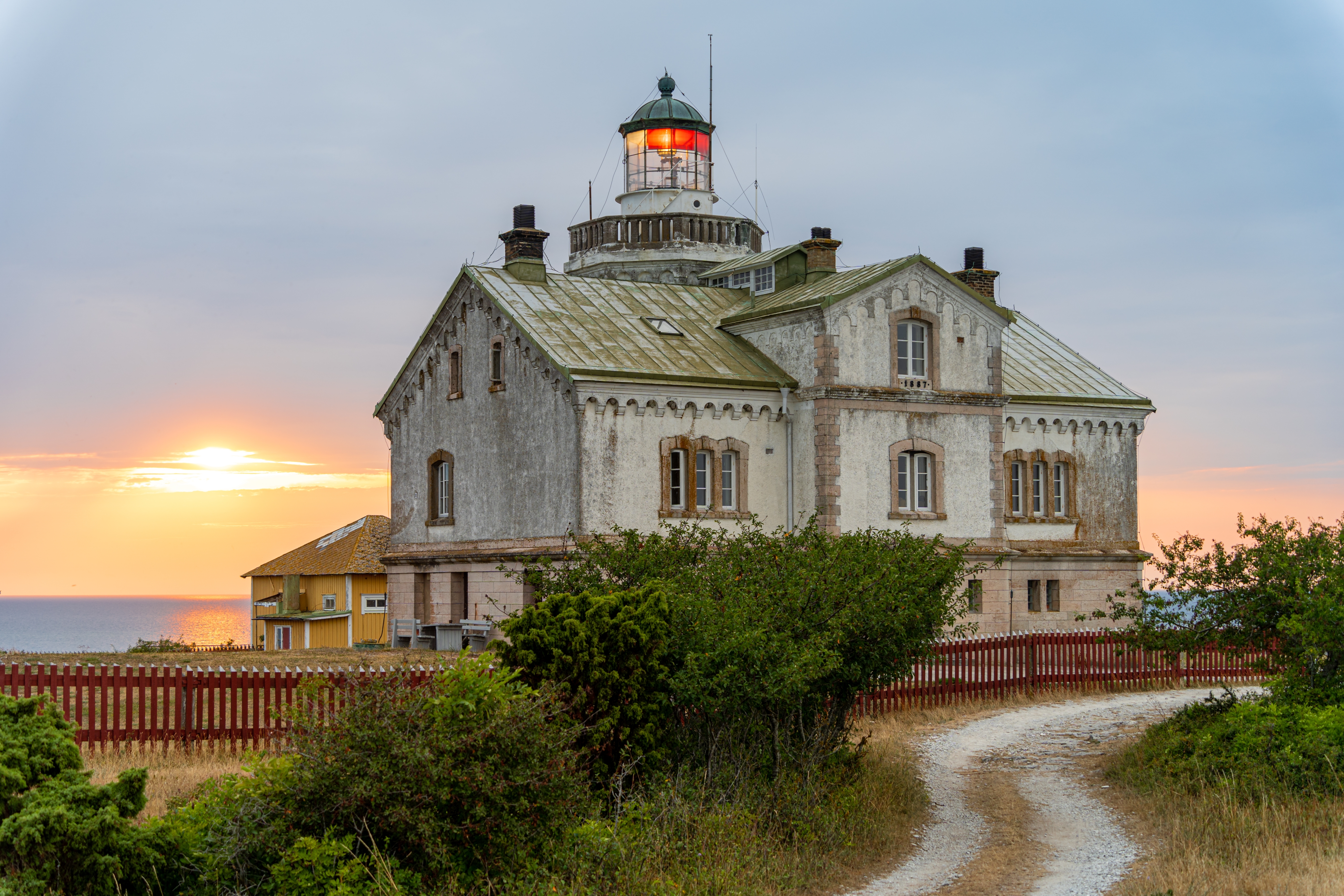 Historisk hvidt fyrtårn på Gotland ø Sverige ved solnedgang med dramatisk himmel
