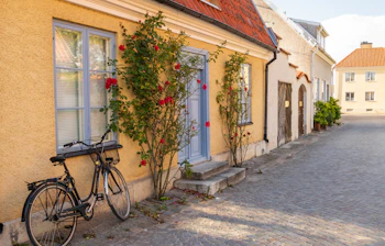 Historisk brostensgade med traditionelle gule huse og cykel i middelalderlige Gotland Sverige