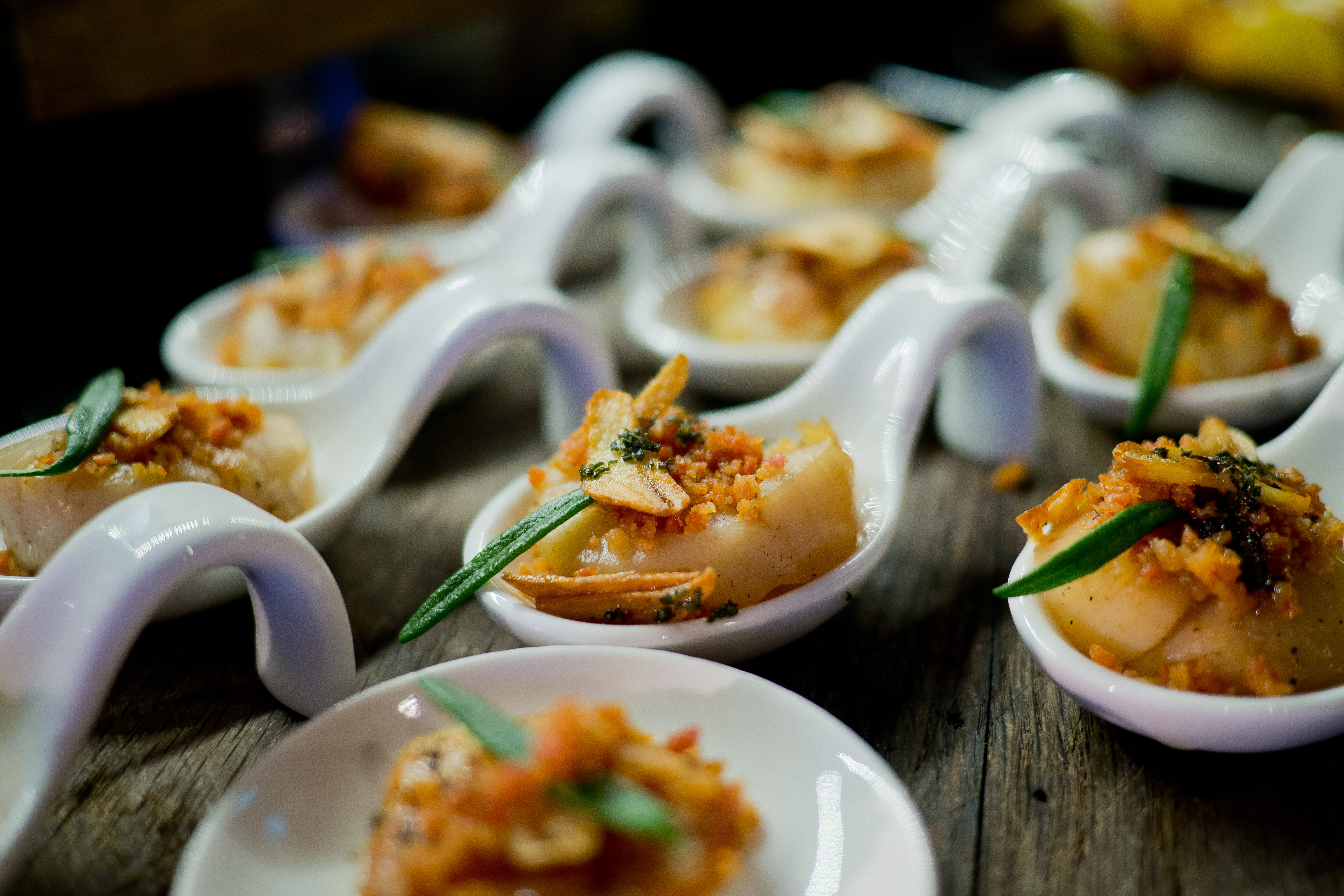 Gourmet canapéer og appetitvækkere serveret i elegante hvide ske på luksus cruise buffet