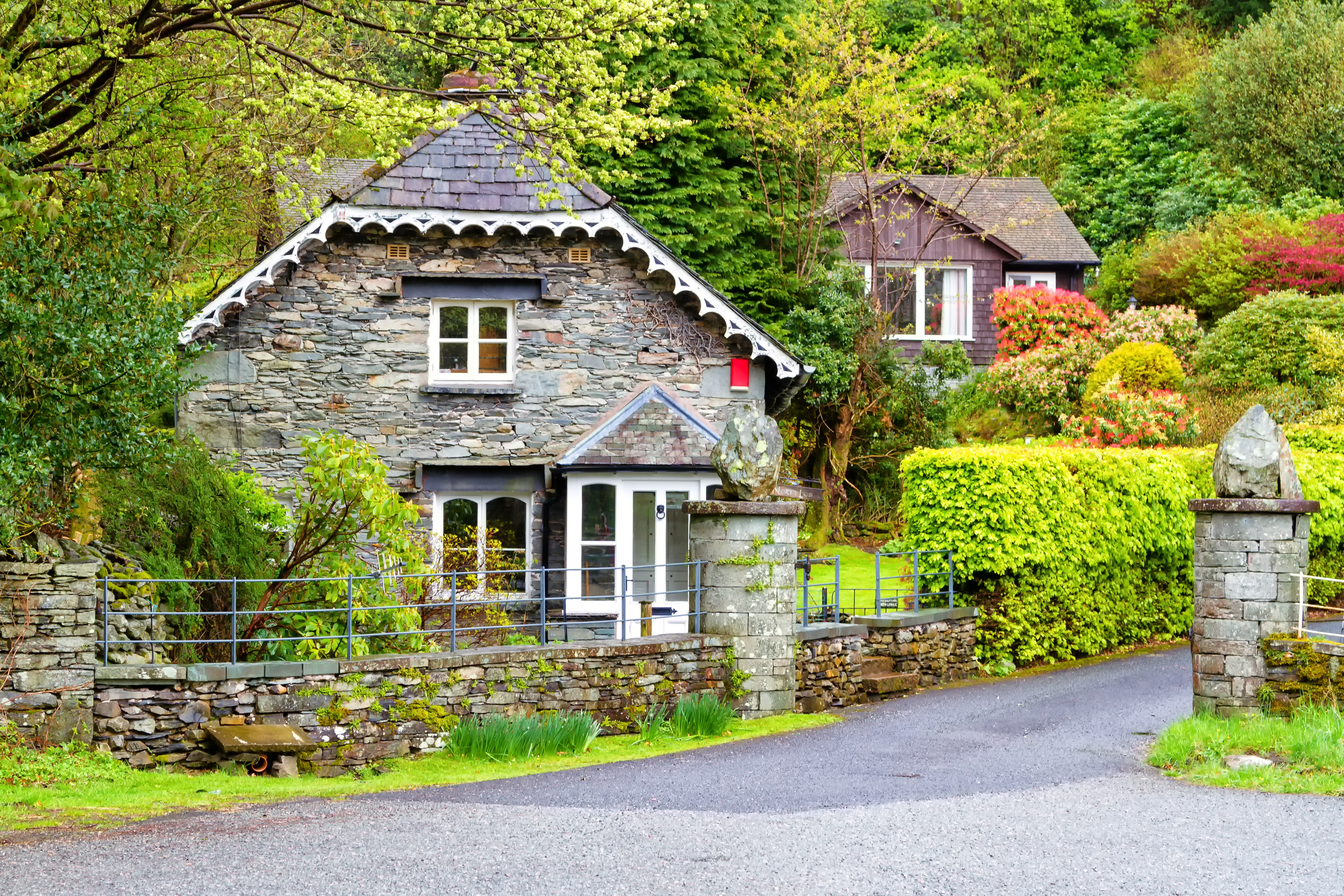 Traditionelt stenhus i Grasmere landsby omgivet af grønne haver i Lake District England