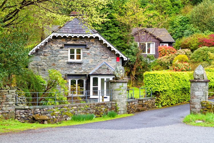 Traditionelt stenhus i Grasmere landsby omgivet af grønne haver i Lake District England