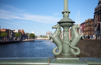Historiske Grattan-broen over floden Liffey i Dublin, Irland på en solrig dag med smuk byarkitektur og blå himmel