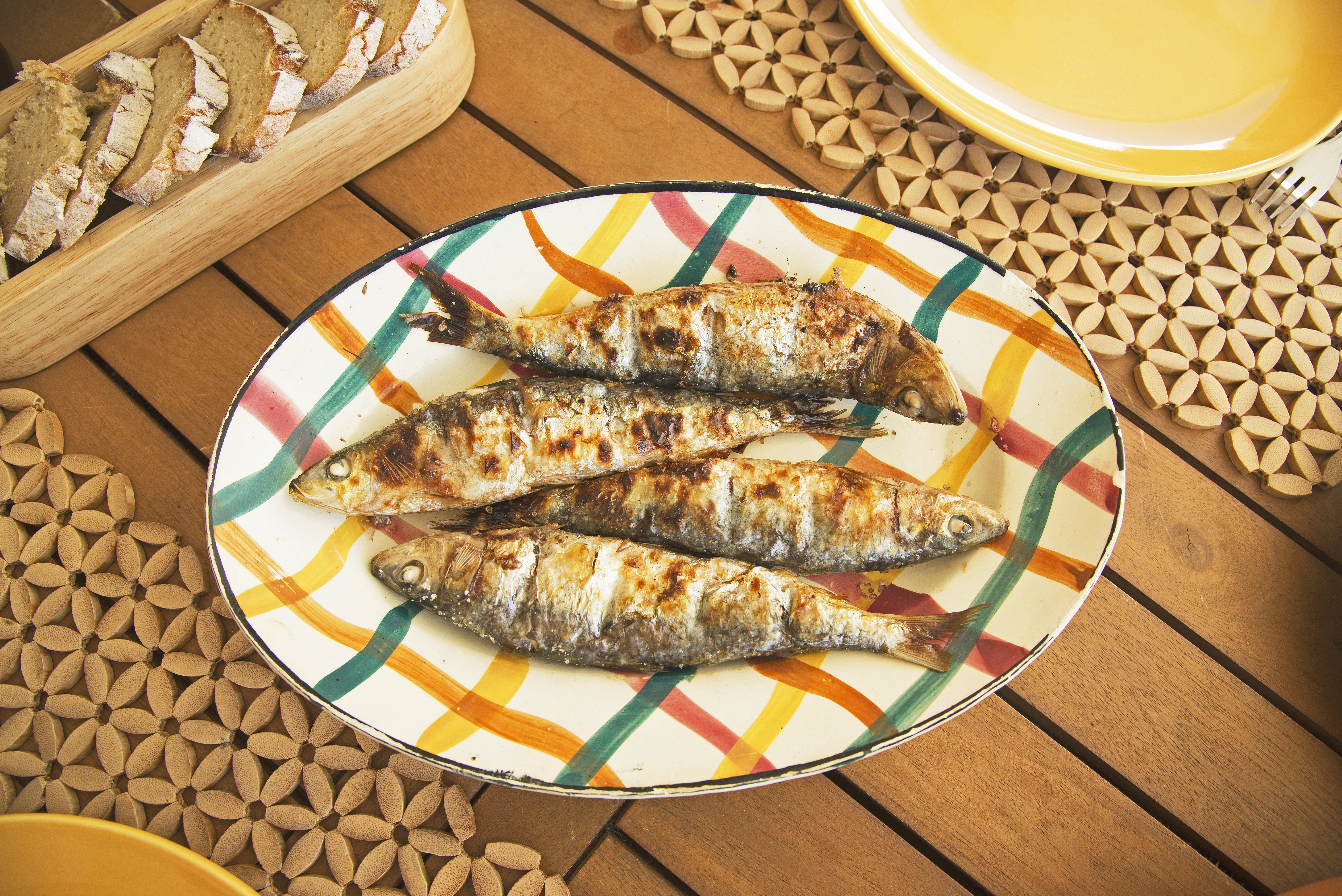 Grillede sardiner på farverig portugisisk tallerken med traditionel middelhavsmad