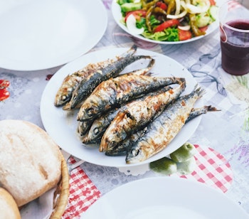 Traditionel portugisisk frokost med grillede sardiner, brød, salat og sangria serveret under San Antonio festivalen i Alfama-kvarteret i Lissabon