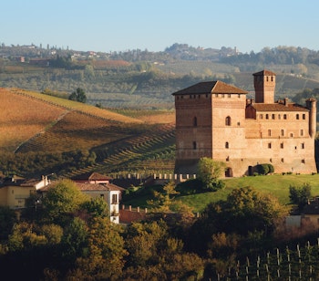 Historiske Grinzane Cavour slot omgivet af gyldne vinmarker ved solnedgang i Langhe-regionen, Piemonte, Italien