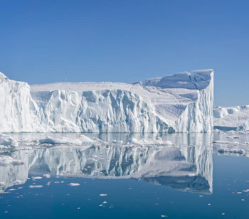 Store isbjerge med spejlblanke refleksioner i Grønlands smukke Disko Bay