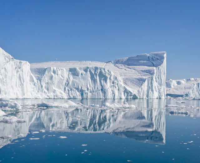 Store isbjerge med spejlblanke refleksioner i Grønlands smukke Disko Bay