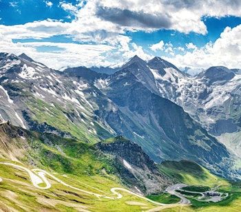 Betagende panoramaudsigt over Grossglockner Højalpine Vej, der snor sig gennem de østrigske alper med majestætiske bjergtinder og grønne dale i Hohe Tauern Nationalpark