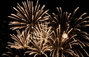 Gyldent fyrværkeri spreder sig mod mørk nattehimmel under festlig fejring