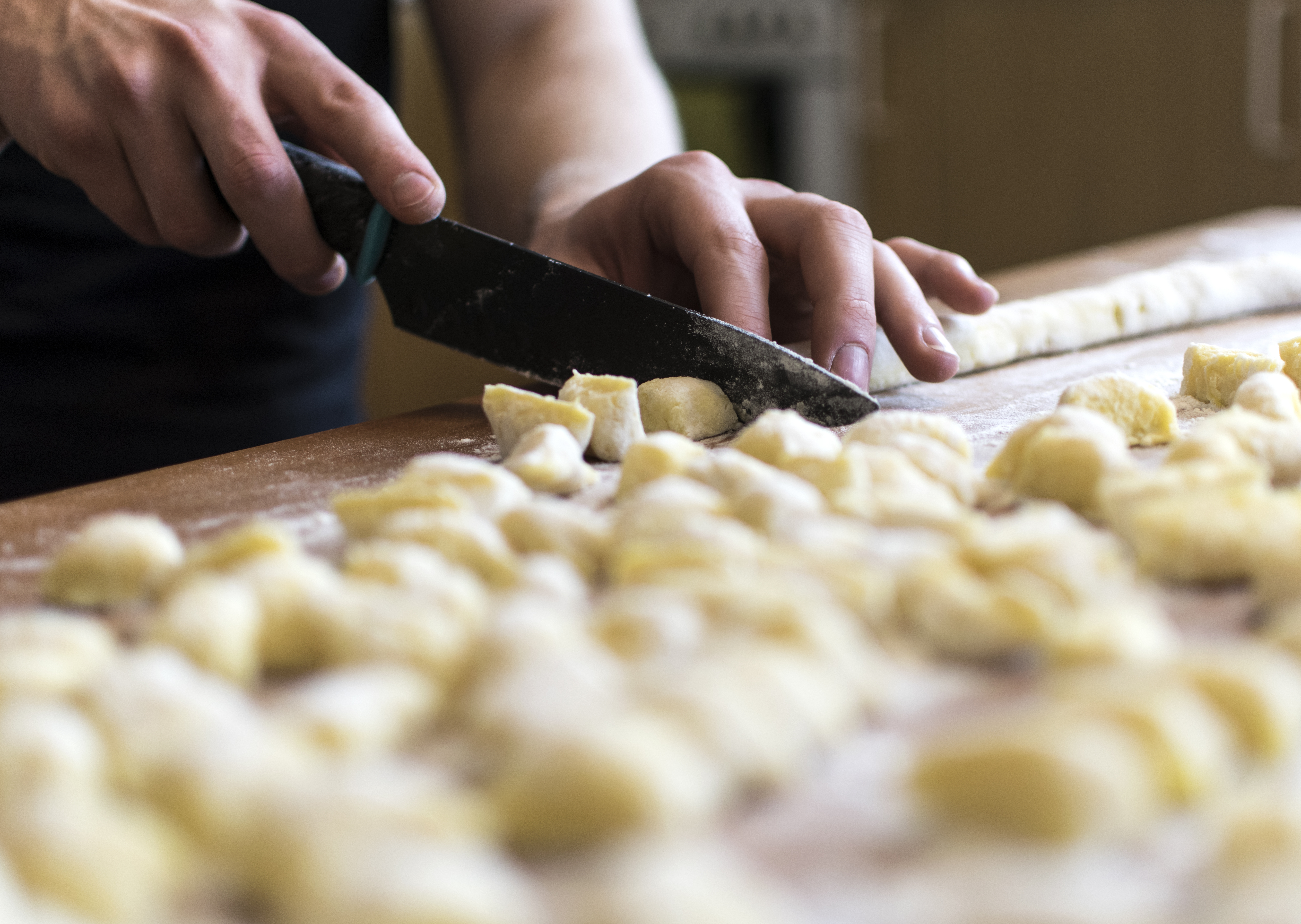 Haender der laver frisk hjemmelavet gnocchi pasta paa traeskaerebraet