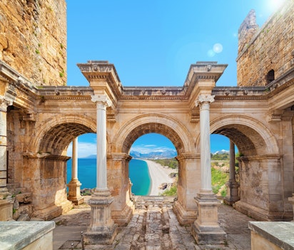 Historiske Hadrians Port i Antalya med tre majestætiske buer der indrammer udsigten til Middelhavet og den tyrkiske kyst