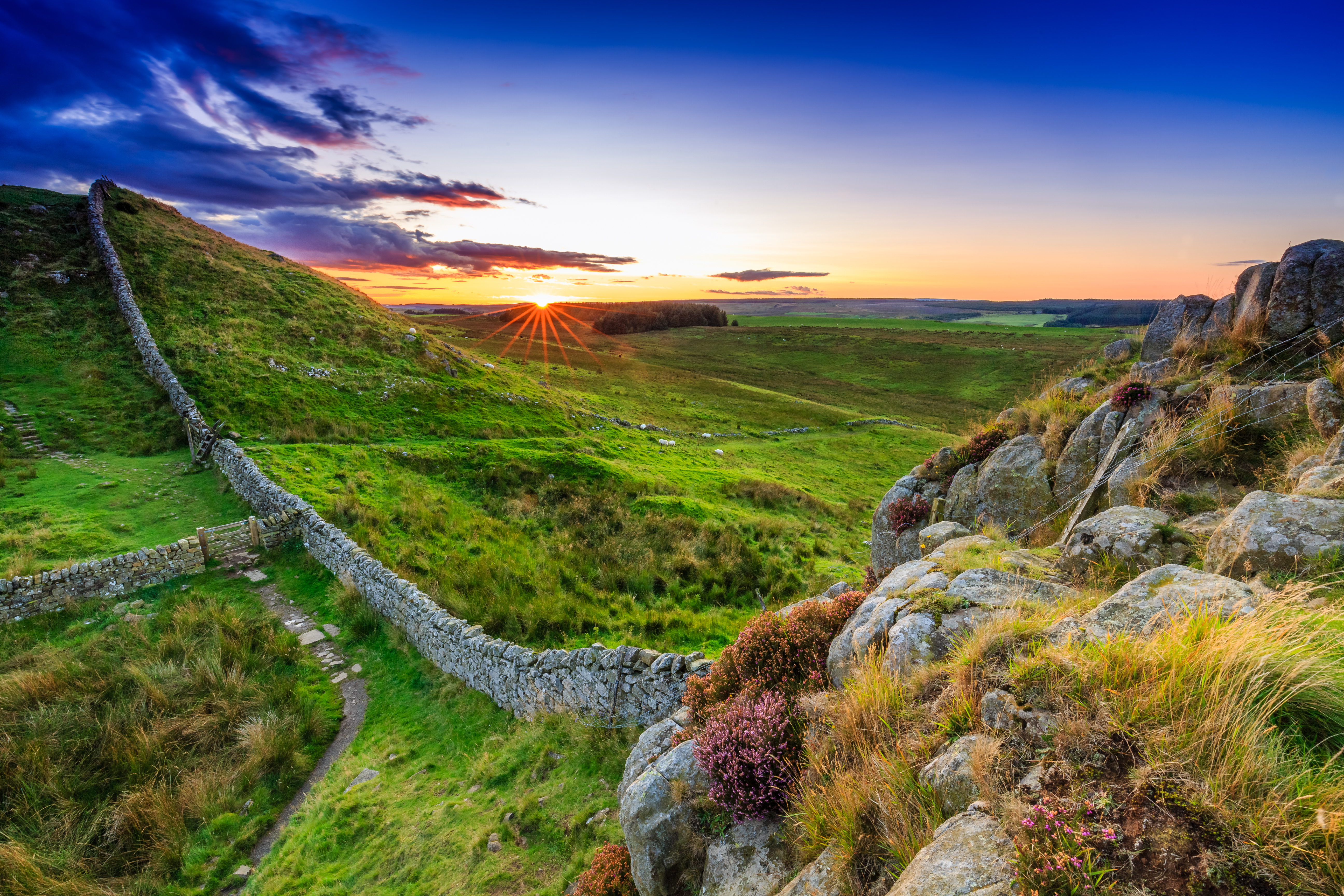 Hadrians Mur ved solnedgang med dramatisk himmel over Northumberland England