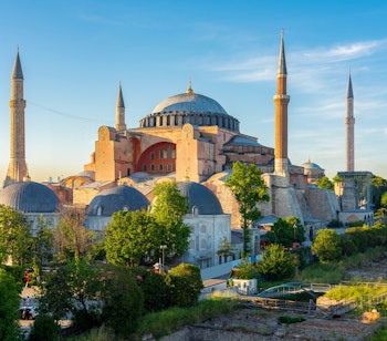 Den historiske Hagia Sophia Grand Moske med dens ikoniske kuppel og minareter ved solnedgang i Istanbul, Tyrkiet